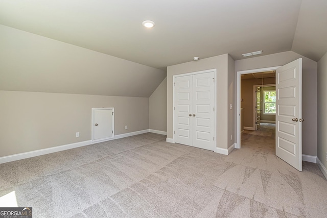 additional living space with vaulted ceiling and light carpet