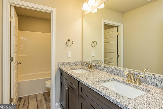 bathroom featuring wood-type flooring, toilet, and vanity