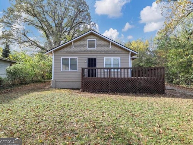 back of house featuring a lawn and a wooden deck