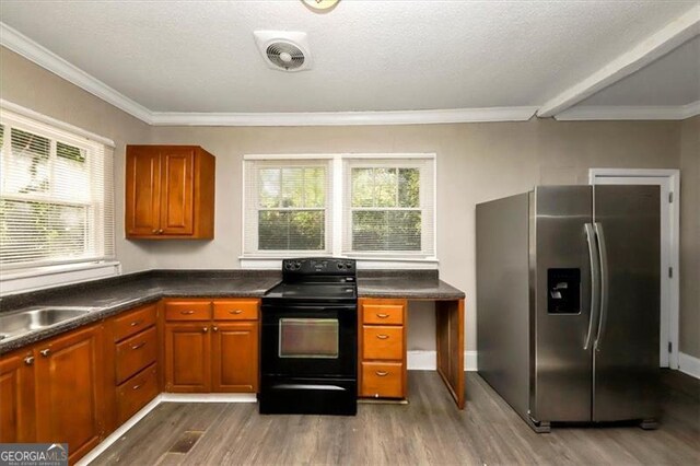 kitchen featuring black range with electric stovetop, stainless steel refrigerator with ice dispenser, dark hardwood / wood-style floors, and plenty of natural light