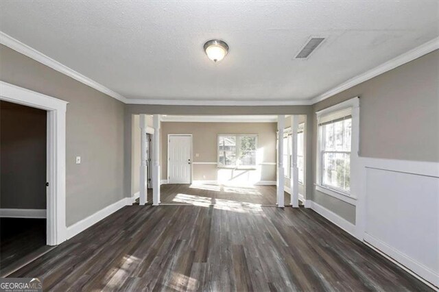 unfurnished living room featuring dark wood-type flooring, a textured ceiling, and crown molding