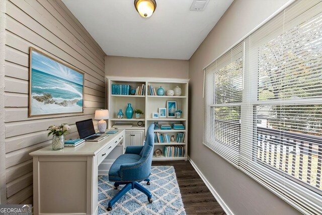 office area with wooden walls and dark hardwood / wood-style floors