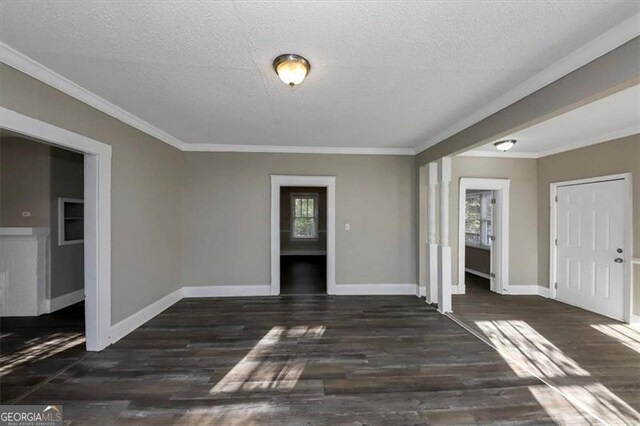 spare room with ornamental molding, dark wood-type flooring, and a textured ceiling