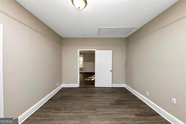 unfurnished bedroom with dark wood-type flooring