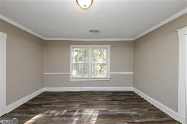 unfurnished room featuring dark wood-type flooring and crown molding