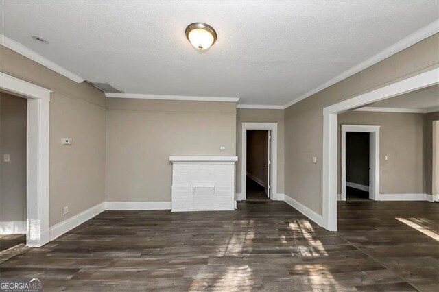 unfurnished living room featuring dark hardwood / wood-style floors, a textured ceiling, and ornamental molding