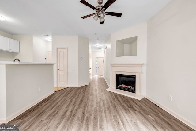 unfurnished living room with hardwood / wood-style floors and ceiling fan