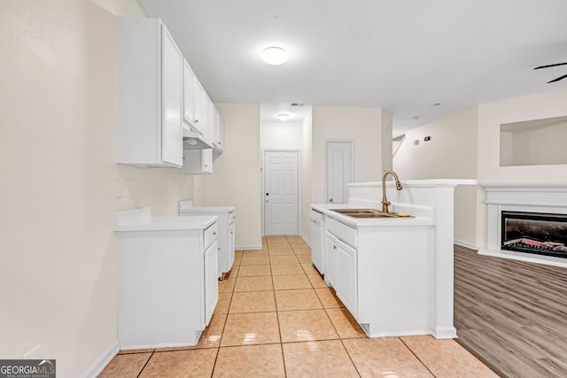 kitchen with white cabinetry, light hardwood / wood-style flooring, range, and sink