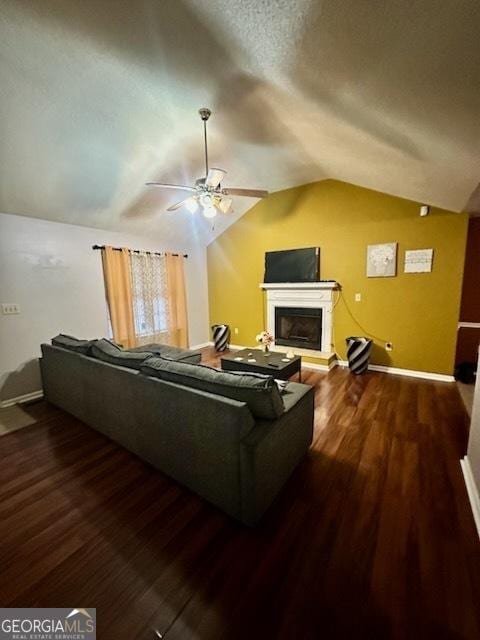 living room with a textured ceiling, ceiling fan, dark wood-type flooring, and vaulted ceiling