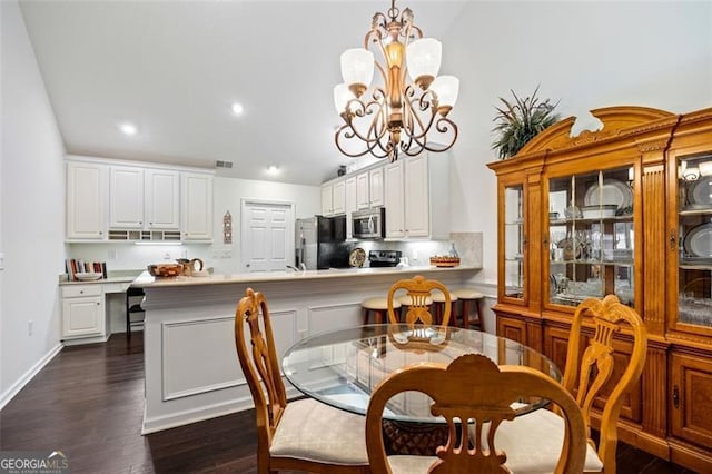 dining area with lofted ceiling, dark hardwood / wood-style floors, and a notable chandelier