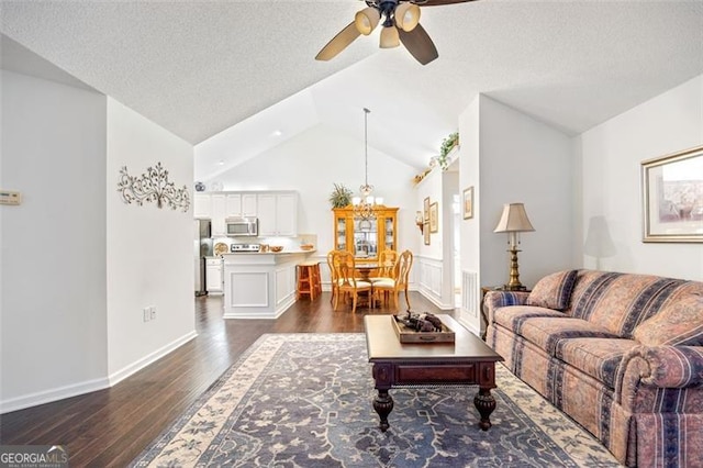 living room with a textured ceiling, dark wood-type flooring, ceiling fan, and lofted ceiling