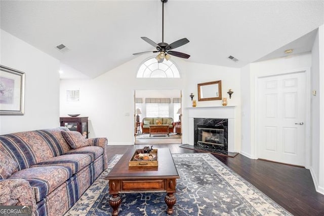 living room with a fireplace, dark hardwood / wood-style floors, ceiling fan, and lofted ceiling