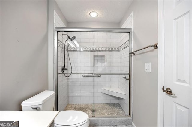 bathroom featuring toilet, vanity, a textured ceiling, and walk in shower