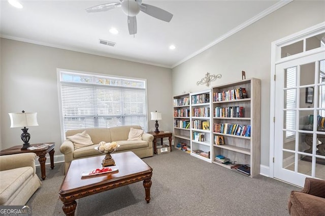 living room with carpet floors, ceiling fan, and crown molding