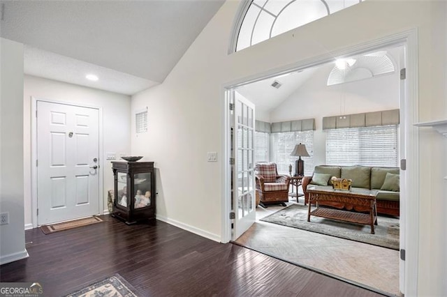 entrance foyer featuring dark hardwood / wood-style flooring and high vaulted ceiling