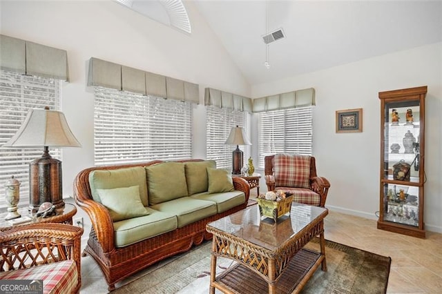 tiled living room with vaulted ceiling and a healthy amount of sunlight