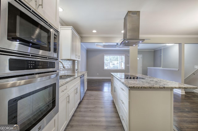 kitchen with stainless steel appliances, a kitchen island, light stone counters, island range hood, and white cabinets