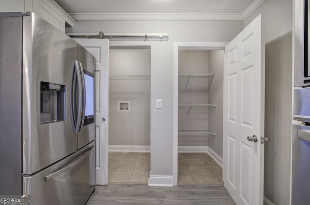 interior space featuring stainless steel fridge, light tile patterned floors, and crown molding