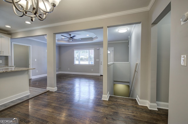 unfurnished dining area featuring dark wood-type flooring, ceiling fan with notable chandelier, and ornamental molding