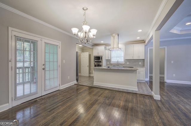 kitchen featuring island exhaust hood, white cabinets, stainless steel appliances, and decorative light fixtures