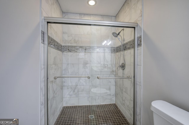 bathroom with toilet and a shower with shower door