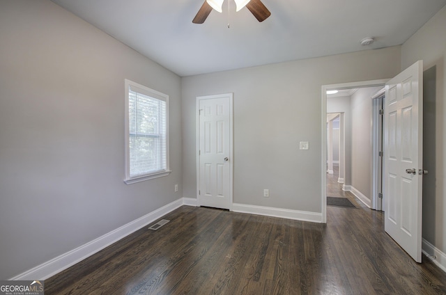 unfurnished bedroom featuring ceiling fan and dark hardwood / wood-style floors