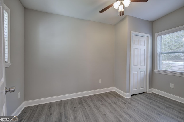 unfurnished bedroom featuring hardwood / wood-style flooring, ceiling fan, and a closet