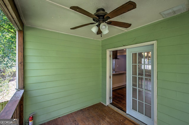 unfurnished sunroom featuring ceiling fan