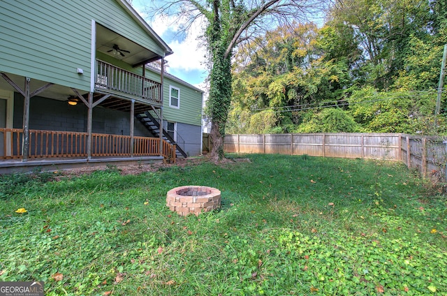 view of yard with a fire pit and ceiling fan