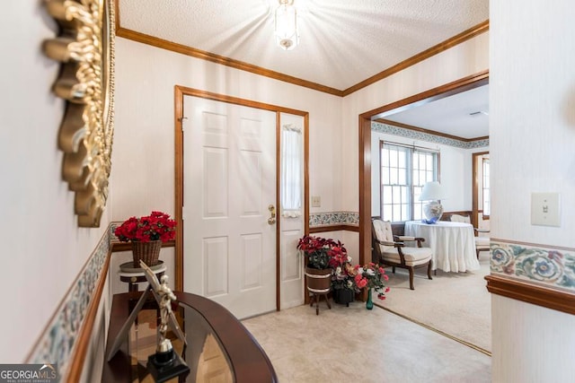 foyer with a textured ceiling and crown molding