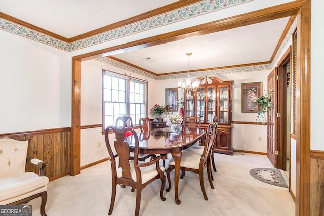 carpeted dining space with wood walls, a chandelier, and crown molding