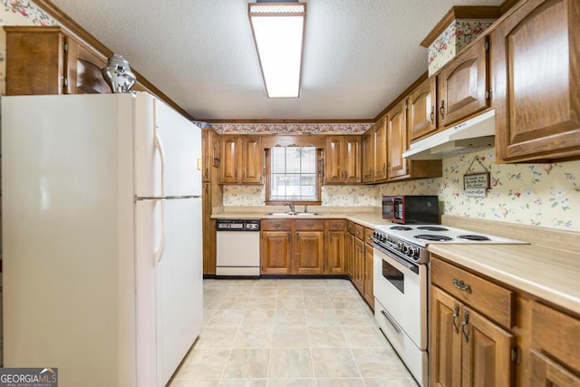 kitchen featuring white appliances, sink, and a textured ceiling