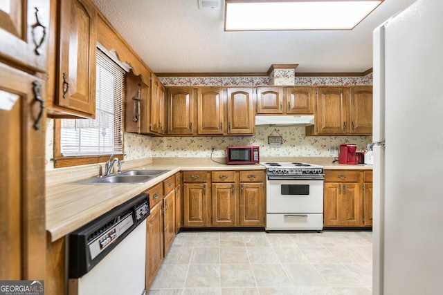 kitchen with white appliances, sink, and a textured ceiling