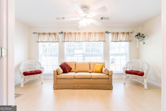 living room with wood-type flooring and ceiling fan