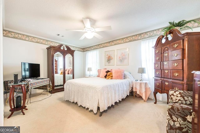 bedroom with ceiling fan, ornamental molding, and light colored carpet