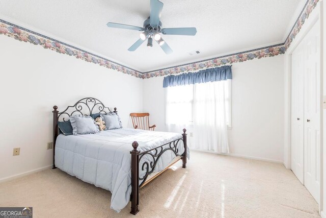 carpeted bedroom with a closet and ceiling fan