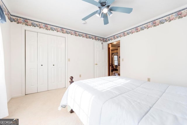 bedroom with ceiling fan, light carpet, and a closet