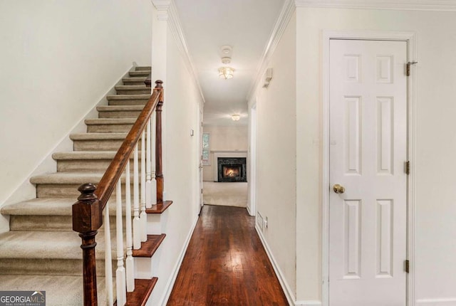 stairs with hardwood / wood-style floors, a high end fireplace, and crown molding