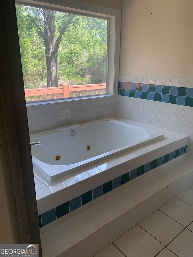 bathroom with tiled bath and tile patterned floors