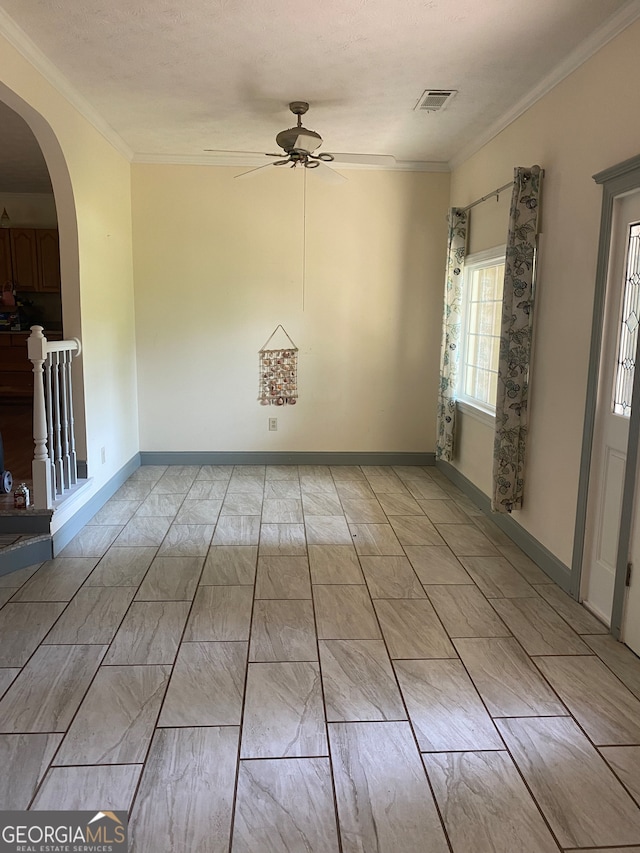 unfurnished room featuring ceiling fan, a textured ceiling, and ornamental molding