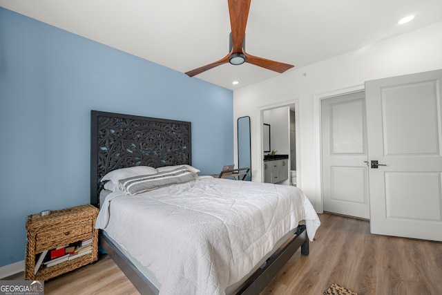 bedroom featuring ceiling fan, connected bathroom, and light hardwood / wood-style flooring