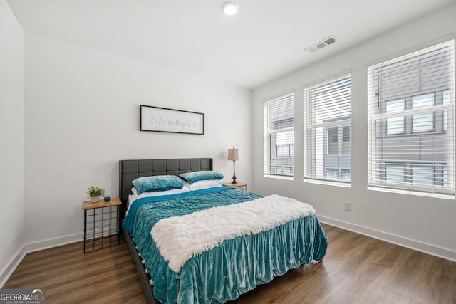 bedroom with dark hardwood / wood-style flooring