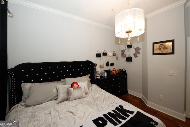 bedroom featuring dark hardwood / wood-style flooring, a notable chandelier, and crown molding