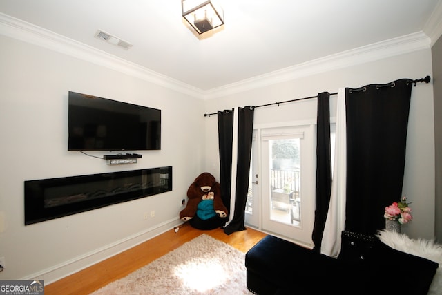 799 Hammond Dr Unit 116, Atlanta, GA 30328 - sitting room with wood finished floors, crown molding, and a glass covered fireplace