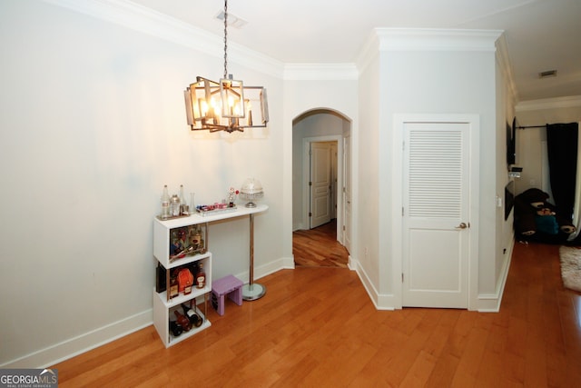 hall with hardwood / wood-style floors, a chandelier, and crown molding