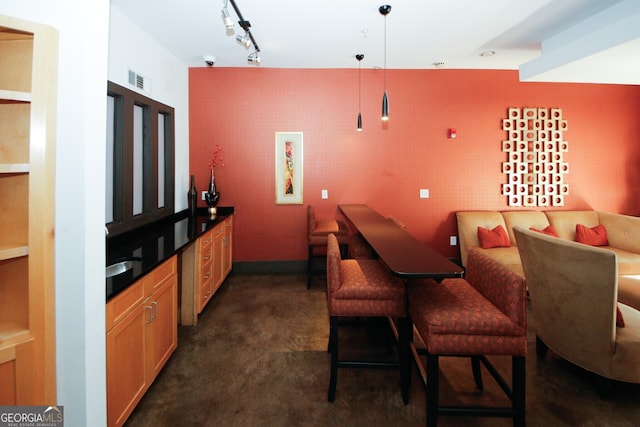 bar featuring hanging light fixtures and track lighting