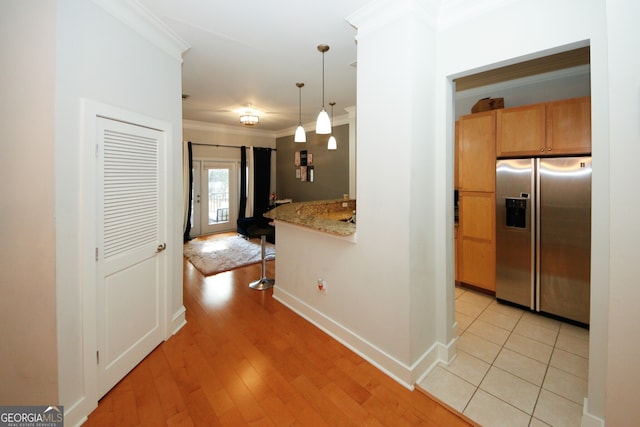 kitchen with stainless steel fridge with ice dispenser, crown molding, and light hardwood / wood-style flooring