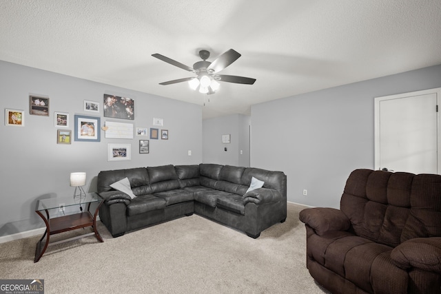 carpeted living room with ceiling fan and a textured ceiling