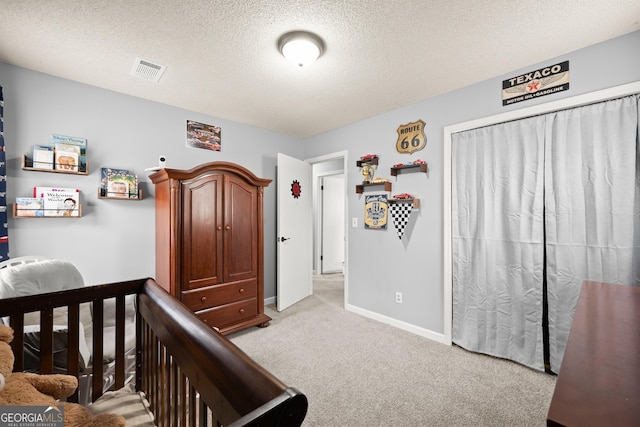 bedroom featuring light colored carpet and a textured ceiling