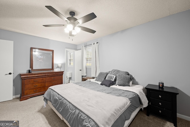 carpeted bedroom with ceiling fan and a textured ceiling